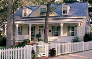 home House with two trees and white fence around it